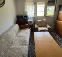 Living room in a family house with a sofa, an armchair, and wooden furniture.