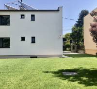 A view of a house with a lawn in Most pri Bratislave, solar panels on the roof.