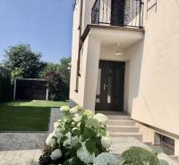 A garden with white flowers and an entrance to a house in Most pri Bratislave.