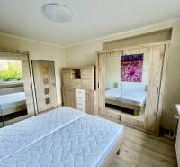 Bright bedroom in a two-room apartment with a spacious wardrobe and a floor with a wooden decor.