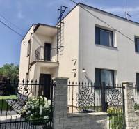 Two-story house with a balcony in Most pri Bratislave, brick fence, garden.