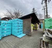 Warehouse of building materials at Strojnická 10 in Ľubotice, surrounded by pallets and products.