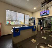 Interior of commercial premises with a reception, shelves, and a window; the room has a television.
