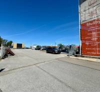 Parking lot at Petrovianska 284 in Prešov, surrounded by commercial properties and advertising banners.