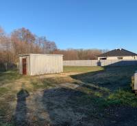 Plots - housing in Malé Leváre with a metal warehouse and grassy area.