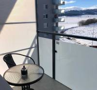The balcony of a studio apartment on Suchoňova Street in Poprad with a view of the snowy landscape.