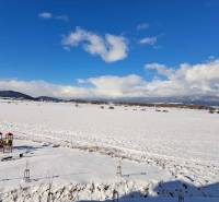 A snowy landscape on Suchoňova Street in Poprad with a view of the children's playground.