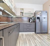 A kitchen in a 3-room apartment with a wooden decor countertop and flooring.