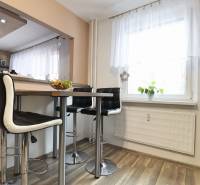 Kitchen corner in a 3-room apartment with a table, chairs, and a window, floor with wooden decor.