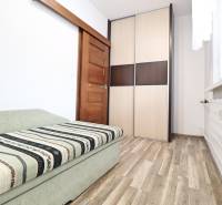 Interior of a 3-room apartment with a sofa, wardrobe, and floor with a wooden decor.
