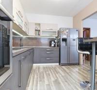 A kitchen in a 3-room apartment with a wooden decor floor and modern appliances.