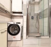 A bathroom in a three-room apartment with a washing machine and a shower.