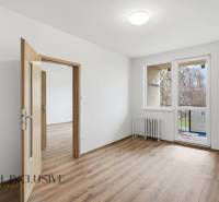 A room in a 3-room apartment with a wooden decor floor and access to a balcony.