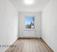 A bright room in a 3-room apartment with a wood-patterned floor and a window on the wall.