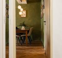Dining table with chairs, green walls, and a chandelier in a 2-room apartment, floor with wood decor.