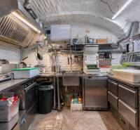 Professional kitchen with stainless steel surfaces and equipment in catering spaces.