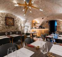 Interior of a gastro space with vaulted stone walls and modern lighting.