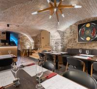 Gastro premises with vaulted brick ceilings and artistic elements, flooring with wooden decor.