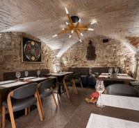 Vaulted ceiling and stone walls with paintings in the dining area.