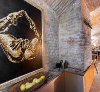 Interior with brick walls, artwork, tables and chairs, dining spaces.