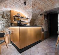 Interior of a gastro space with a vaulted brick ceiling and a bar counter.