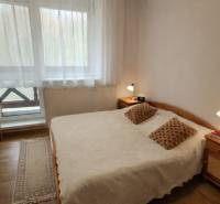 Bedroom in a 3-room apartment with a wooden decor floor and a large window.