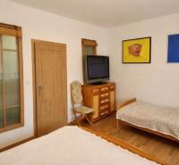 A bedroom in a 3-room apartment with two beds, a television, and a wooden decor floor.