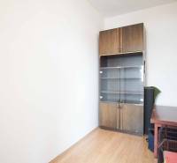 A room in a 3-room apartment with a wood-patterned floor and a cabinet.