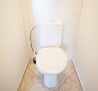 A toilet with a tiled floor in a 3-room apartment.