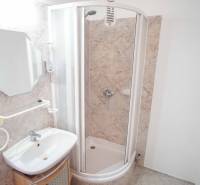 A bathroom in a 3-room apartment with a corner shower and a sink.