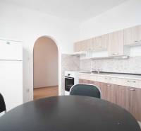 A kitchen in a 3-room apartment with an arched passage and a floor with a wood decor.