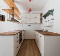 A kitchen corner in a 2-room apartment with wooden decor and pendant lights.
