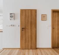 Interior of a 2-room apartment with a wooden decor floor and wooden doors.