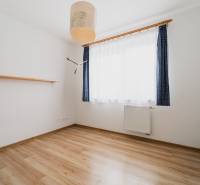 A bright room with a shelf and a wooden decor floor in a two-room apartment.