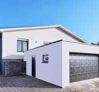 Family house on Belža Street in Belža with a light facade and a garage.