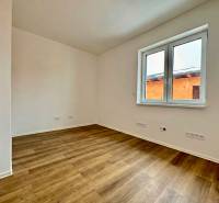 A room in a family house with white walls and a wooden decor floor.