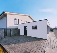 A family house in Belža on Belža Street with a paved courtyard and a garage.