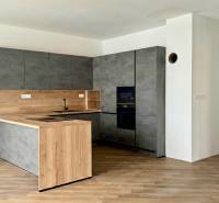 A kitchen in a family house with a wooden decor floor and dark gray cabinets.