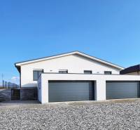 A family house in Belža on Belža Street with two garages and a gravel forecourt.