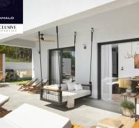 Exterior of the villa with a terrace in Labin. Relaxation loungers, hanging chair, dining area.