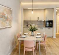 Dining room and kitchen in a 2-room apartment with a wooden decor floor and an artistic painting.