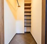 A pantry with built-in shelves and a simple hanging system in a 2-room apartment.