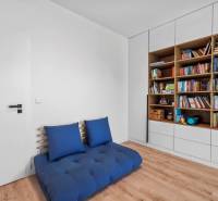 A room in a family house with a comfortable armchair and a full bookshelf.