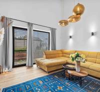Living room in a family house with a large yellow sofa and a blue carpet.