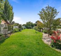 A garden with a lawn and flowers at a family house on Školská Street in Láb.