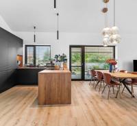 A bright kitchen in a family house with stylish furniture and a dining table.