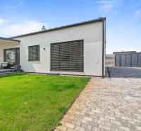 A family house on Školská Street in Láb, a terrace with seating and a manicured lawn.