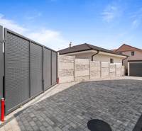 A family house in Lábe on Školská Street with a gate and a landscaped yard.