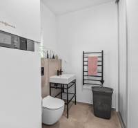 A bathroom in a family house with a wall-hung toilet, a sink, and a towel radiator.