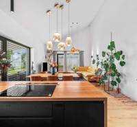 Kitchen and living room in a family house with comfortable seating and pendant lights.